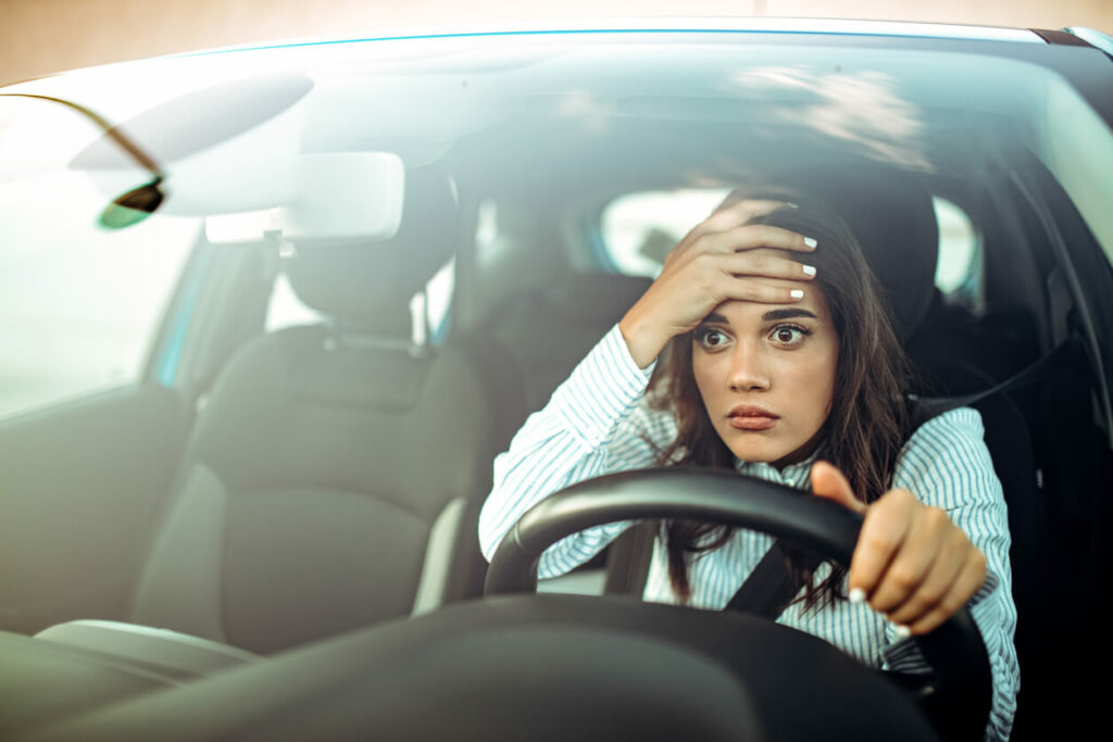 A woman driving a car and being confused.