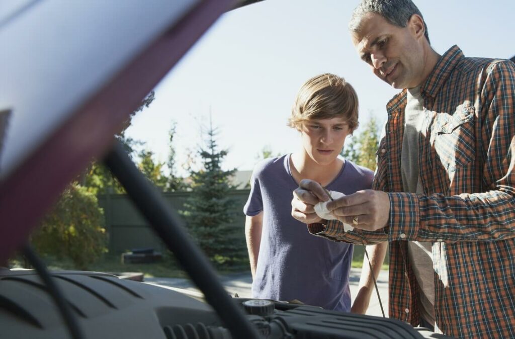 Father and son working on a car engine.