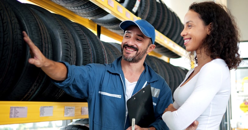 Man helping female customer choose new tires.