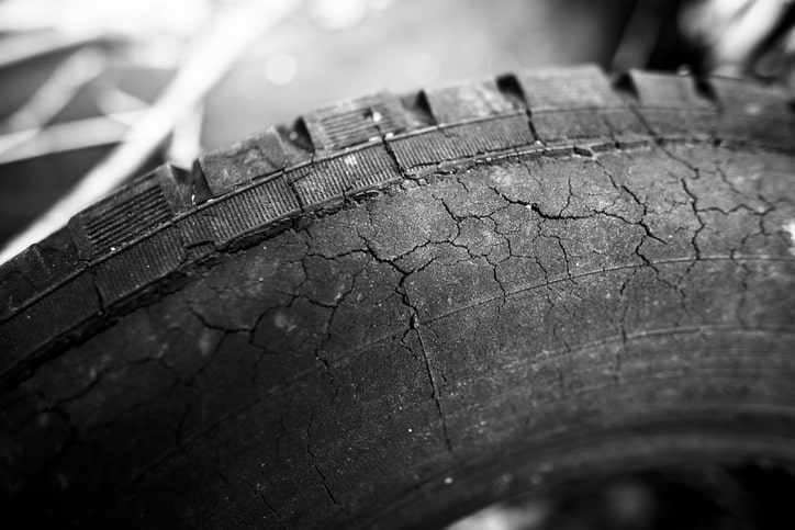 Worn tire tread with cracks.