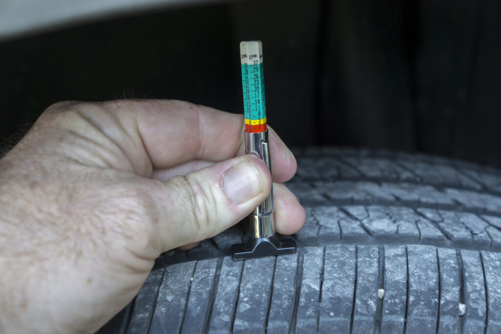 Measuring tread wear on a tire on a car.
