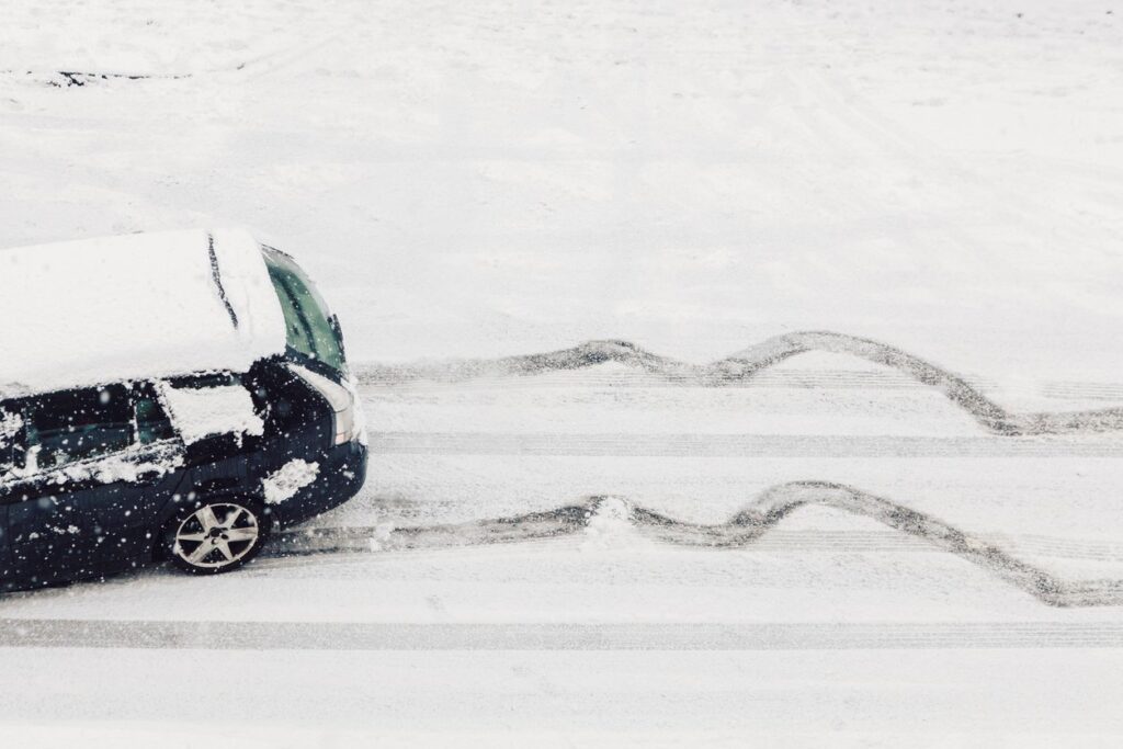 A car skids on an icy, snowy road.