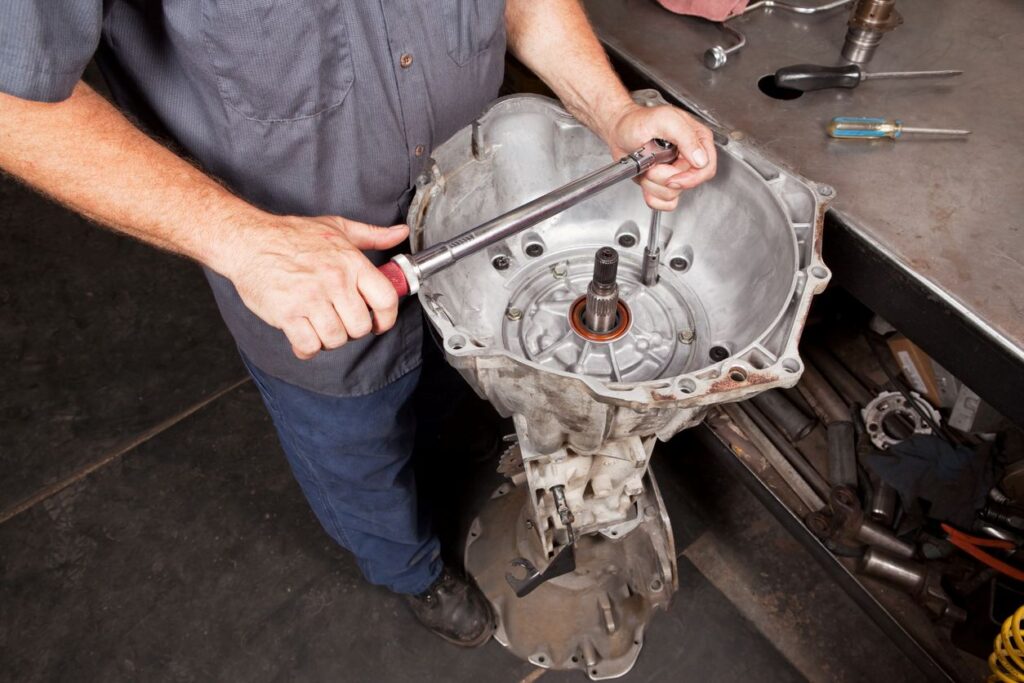 An automotive tech disassembles an automatic transmission to repair an issue.